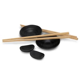 A sushi set featuring black ceramic plates, wooden chopsticks, and small dipping bowls.