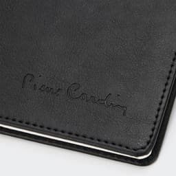 A black diary with a textured cover and embossed branding, featuring white stitching along the edges.