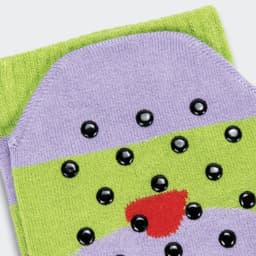 A pair of purple and green grip socks featuring black dots and a red accent, with a logo on one side.