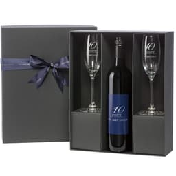 Custom labelled red wine bottle in a premium black gift box with two clear glasses. Features a branded logo.